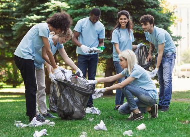 Genç gönüllüler parkta çöp topluyor, ekoloji konsepti, kopyalama alanı