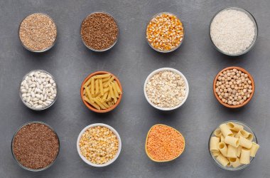 Sağlıklı tanecikler ve gri arka planda karbonhidrat dolu erişteler.