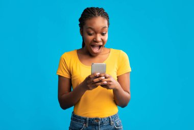 Blue Stüdyo Arkaplanında İnternet Taraması yapan Heyecanlı Siyah Kadın. Harika Haber Konsepti