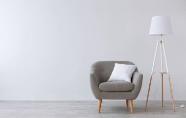 Modern İskandinav salonu ya da ofis içi. Beyaz yastıklı klasik gri koltuk, ahşap zeminde lamba, oturma odasındaki ışık duvarı arka planı, düz yatak, fotokopi odası, stüdyo çekimi, maket