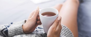 Yatakta rahat vakit. Fincan sıcak çay, pov, kopya alanı ile tutan genç kız