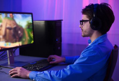 Çevrimiçi Oyun. Oyuncu adam geceleri evdeki masaüstü bilgisayarında oyunlar oynuyordu. Seçici Odaklanma, Düşük Işık