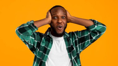 Omg. Şaşırtıcı bir şekilde Afrikalı Amerikalı bir adamın kameraya bakıp sarı stüdyonun arka planında durmasına şaşırdım. Wow Haberler Konsepti. Reklam afişi. Panorama