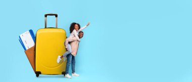 Neşeli bir turist çift, seyahat planlarını kutlamak için parlak sarı bir bavulun yanında duruyor. Yaz maceraları için hazırlar, kopyalama alanı.