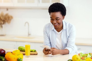 Sağlıklı Beslenme Uygulaması. Çevrimiçi Akıllı Telefon Tarama Tarama Tarama Reçetesi kullanan Afrikalı Amerikalı Kadın veya Evde Mutfakta Yemek Hazırlama Uygulaması.