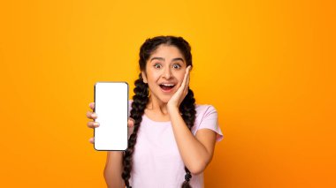İnanılmaz Faydalı Uygulama. Heyecanlı ve şaşırmış Hintli genç bir kadının portresi elinde siyah bir ekranla akıllı telefon tutuyor, cihazını gösteriyor. Şablon oluşturmak için boş boş alanı olan Gadget