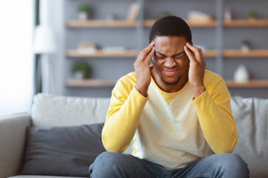 Afro-Amerikalı genç adamın baş ağrısı var, şakaklarına dokunuyor. Evdeki kanepede oturup, fotokopi odası olan bir panorama izlemek. Zenci adam akşamdan kalma ya da migren ağrısı çekiyor.