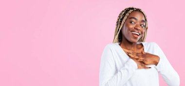 Teşekkür ederim. Minnettar genç siyahi kadın ellerini göğsüne bastırıyor pembe stüdyonun arka planında minnet pozu veriyor ve fotokopi uzayına bakıyor. Takdir kavramı