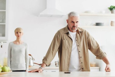 Tartışma ve suçlamadan sonra kızgın çift, üzgün koca ve kızgın eş, kötü evlilik ilişkisi, mutsuz aile, evde kavga. Yetişkin adam ve bayan, modern mutfağın içindeki büyük kavgadan sonra sessiz kaldılar.