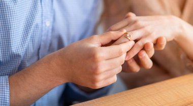 Milenyum erkeğinin sevgili eşine içeride evlenme teklif edişini, parmağına elmas yüzük takışını, ellerinin yakın plan oluşunu. Nişan, evlilik, düğün konsepti