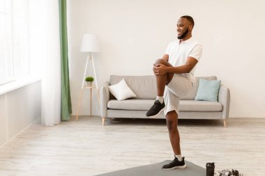 Siyahi adam bacak egzersizi yapıyor. Sabahları evde antrenman yapıyor. Ev Sağlığı ve Spor Yaşam Tarzı Konsepti. Metin için Boş Alan