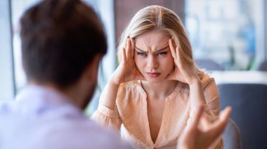 İlişki sorunları, boşanma, ayrılma kavramı. Kafede erkek arkadaşıyla kavga eden mutsuz genç bir kadın. Milenyum çifti kavga ediyor ve tartışıyor, zorluklar yaşıyor ya da yanlış anlaşılıyor.