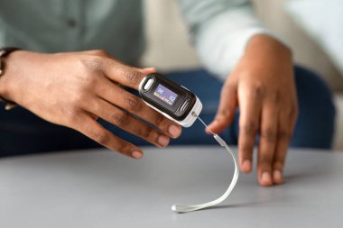 Tanınmayan Afrikalı Adam Nabız-Oksijen Doygunluğunu ve Nabız Değerlerini Evde Kontrol Ediyor. Nabız oksimetri Tıbbi Cihazı Ox seviyesini ölçüyor. Kırpılmış, Seçici Odaklanma