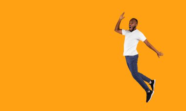 Stüdyoda açık ağızlı, sarı arka planda mesaj pozu veren duygusal siyahi adam şaşkınlıkla yan yana atlıyor. Tam Uzunluk, Panorama