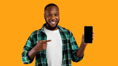 Harika Mobil Uygulama. Siyah Adam, Smartphone Boş Ekranı Kameraya Gösteriyor Parmak Gösterme Uygulaması Sarı Stüdyo Arkaplanının Üzerinde Duruyor. Şuna bir bak. Panorama, Mockup