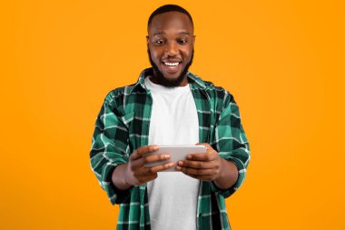 Mutlu Siyahi Milenyum Adamı Akıllı Telefon Kullanıyor Oyun Online Olarak Sarı Arkaplanda Duruyor. Gezici Oyun Konsepti. Harika Uygulama Reklamı. Stüdyo Çekimi