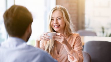 Güzel bir milenyum kadını kafede erkek arkadaşıyla sohbet ediyor, sevgilisiyle vakit geçiriyor, kahve içiyor. Sevecen genç çift kafeteryada romantik bir randevuda flört ediyor.