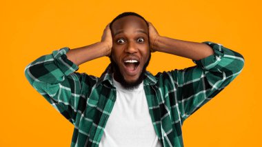 Omg. Shocked African American Man Shouting Looking At Camera Touching Head Posing Standing Over Yellow Background. Wow News Concept. Panorama, Studio Shot