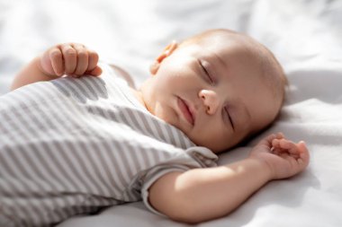 Sevimli, yeni doğmuş bir bebeğin yatakta tek eliyle uyuması, güzel bir erkek ya da çizgili takım elbiseli bir kızın evde uyuması, gündüz uykusunun keyfini çıkarması, beyaz çarşafların üzerinde dinlenmesi, kırpılmış görüntüler.