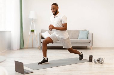 Çevrimiçi antrenman. Afro-Amerikalı adam evdeki dizüstü bilgisayar eğitiminde spor yaparken spor yapıyor. Uzak Dijital Spor Salonu Web Sitesi, Modern Spor Yaşam Tarzı Konsepti