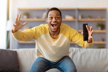 Mutlu Afro-Amerikan erkeği evde eğleniyor, uzaktan kumandayla bağırıyor, televizyonda futbol maçı seyrediyor, uzay boşluğu. Zenci adam hafta sonunun tadını çıkarıyor, oturma odasında televizyon seyrediyor.