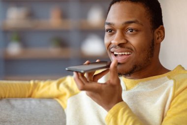 Siyah adamın sesli mesaj kaydettiği, akıllı telefon kullandığı, fotokopi çekilen yere baktığı yakın plan. Yakışıklı Afrikalı Amerikalı genç adam cep telefonuyla arkadaşlarıyla sohbet ediyor, telefonda başvuru yapıyor.