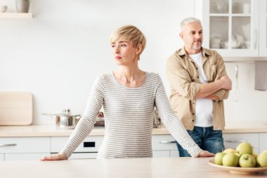 Evde kavga, kovid 19 tecridi sırasında ilişki sorunları. Son sınıf öğrencisiyle kadını gücendirmiş. Modern konforlu hafif mutfak mutfağında yaşanan skandaldan sonra birbirlerini görmezden gelmişler. Bulaşıklar, boş yer.