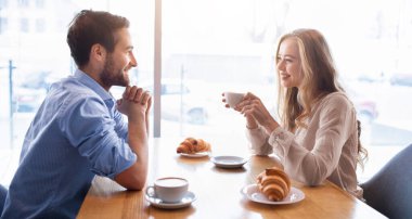 Sevecen genç bir çift kafeteryada brunch yapıyor, pencerenin yanında arkadaşça sohbet ediyor, kahve içiyor. Güzel bir kadın ve yakışıklı erkek arkadaşı romantik bir randevu sırasında sohbet ediyorlar.