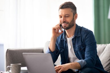 Bilgisayarla çalışan gülümseyen iş adamı cep telefonu, ev içi, fotokopi odası gibi yerlerde sohbet ediyor. Evden çalışan mutlu orta yaşlı bir adam, akıllı telefondan müşterilerle konuşuyor.