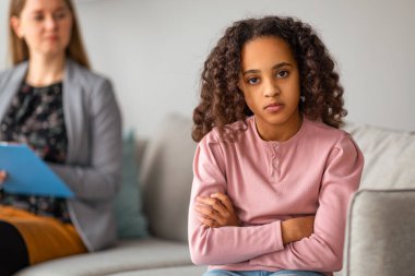 Psikolojik yardım ve yardım. Üzgün kız doktoruna geri dönüp kameraya bakıyor. Psikolog danışmanlık ofisteki ya da evdeki terapi seanslarında gençleri vurguladı