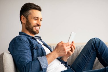 Evdeki koltukta rahat rahat dinlenen mutlu orta yaşlı bir adam modern akıllı telefon ve fotokopi odası kullanıyor. Yakışıklı sakallı adam blog okuyor ya da en yeni cep telefonuyla oyun oynuyor, hafta sonları eğleniyor.