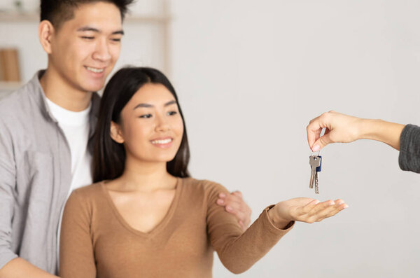 Новый дом. Портрет китайской пары арендаторов, получающих ключи от агента по недвижимости, Copyspace
