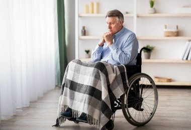 Huzurevlerindeki engelli yaşlıların yalnızlığı. Tekerlekli sandalyedeki engelli adam depresyon ya da stresten içeride yatıyor, uzun bir portre.