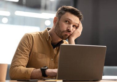 Sıkıcı iş. Bilgisayarın başında oturan mutsuz iş adamı, bilgisayar çalışmasından sıkılmış, modern ofisteki sorunları düşünüyor. İş Sorunları ve Girişimcilik Zorlukları Konsepti