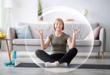 Huzurlu, mutlu, olgun Avrupalı kadın oturma odasında meditasyon yapıyor koruyucu balonun içinde. Dinlen, rahatla ve salgın sırasında evde sağlıklı bir yaşam sür. Spor yurt içi spor salonu