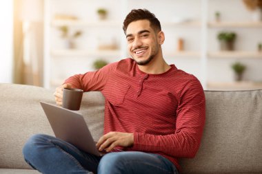 Evdeki koltukta oturan rahat Arap adam, dizüstü bilgisayar kullanıyor ve gülümsüyor, kahve içiyor ve internetten film izliyor, kopya çekiyor. İnternette sörf yapan, hafta sonları dinlenen mutlu bir ortadoğulu.