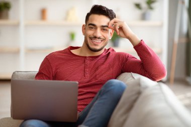 Kanepeye dizüstü bilgisayarla yaslanmış, kameraya gülümseyen, ev içi, fotokopi çeken bir adam. Mutlu ortadoğu milenyumu erkekleri hafta sonları dinlenirken film izleyip web sörfü yapıyor.