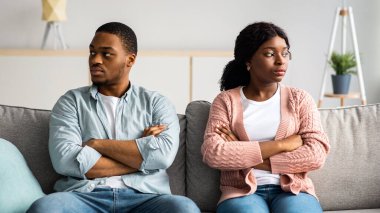 Hayal kırıklığına uğramış Afro-Amerikan çift kollarını göğsüne bağlamış genç bir adam ve kadın ilişki krizi yaşıyor, koltukta oturuyor ve yan yana bakıyor, kavgadan sonra birbirleriyle konuşmuyorlar.