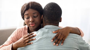 Namussuz genç siyahi kadın erkek arkadaşına ya da kocasına sarılıyor ve aşağıya bakıyor, kendini yalnız hissediyor ya da sevgilisine karşı dürüst davranmıyor. Aldatma, güvensizlik, ilişki konseptinde soğukluk