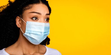 Yüzünde Koruyucu Tıbbi Maskeli Endişeli Siyah Kadın portresi, Coronavirus salgınından korkan Milenyum Afrikalı Amerikalı Kadın, Sarı Arkaplan, Özgür Alan