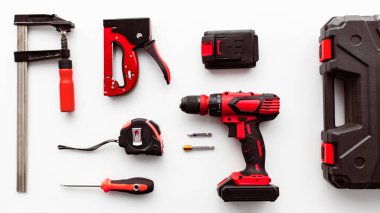 Profesyonel inşaat malzemeleri seti. Beyaz arkaplandaki çeşitli enstrümanlar, üst görünüm. Alet çantası, elektrikli matkap, cetvel ve klemp araçları, düz konum