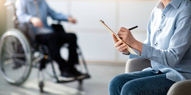 Ofiste tekerlekli sandalyedeki özürlü ergenlerle çalışan bir kadın psikolog. Mutsuz engelli bir gencin klinikte psikoterapistle görüşmesi, seçici odaklanma