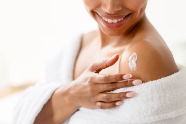 Vücut Bakımı. Evdeki modern banyoda banyo yaptıktan sonra cilt nemlendirici krem süren güzel siyah kadın. Spa Güzellik, Şımartma ve Sağlık Konsepti