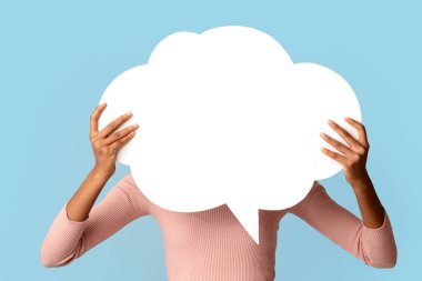 Yüzünün önünde boş bir konuşma balonu tutan tanınmayan siyah kadın, geri bildirim ya da reklam için boş alan gösteren Afrikalı Amerikalı kadın Mavi Arkaplan 'ın üzerinde dururken