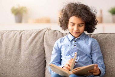 Boş zaman kavramı. Elinde kağıt kitap tutan ve okuyan sevimli, gülümseyen zenci kız portresi, evde oyuncak ayıyla kanepede oturup masal dinlemek, fotokopi çekmek. Gençler dinleniyor ve dinleniyor.