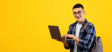 Sırt çantalı zeki genç bir öğrenci turuncu stüdyo geçmişinde dizüstü bilgisayar kullanıyor. Çevrimiçi çalışan olumlu milenyum adamı, internetten ailesiyle ya da arkadaşıyla sohbet ediyor, uzaktan derse katılıyor.