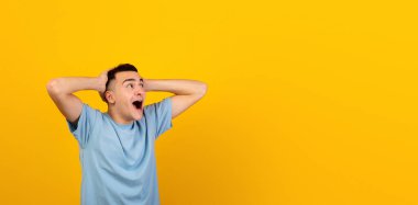 Havalı genç adam şok içinde başını tutuyor, aman tanrım diye bağırıyor ve turuncu stüdyo arka planındaki boş alana bakıyor, afiş tasarımı. Kafkasyalı adam büyük satış ve tanıtıma inanamıyor.