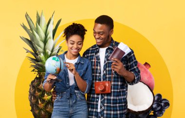 Neşeli bir çift, etrafları ananas ve nar gibi canlı meyvelerle çevriliyken bir küreyle meşgul olur. Sağlıklı beslenme ve seyahat deneyimlerini neşe ve heyecanla kutlarlar..