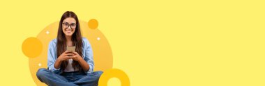 Genç bir yetişkin öğrenci bacak bacak üstüne atmış, elinde akıllı bir telefonla oturuyor ve gülümsüyor. Arkaplan, geometrik şekillerle parlak sarıdır, modern eğitim ve öğrenim için hoş bir atmosfer yaratır..