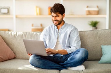 Uzaktan kumanda. Evde dizüstü bilgisayarda çalışan, bacak bacak üstüne atmış koltukta oturan, uzak mesafelere giden iş olanaklarının tadını çıkaran Arap bir serbest yazar. Genç adam evde eğleniyor, bilgisayardaki arkadaşlarıyla sohbet ediyor.